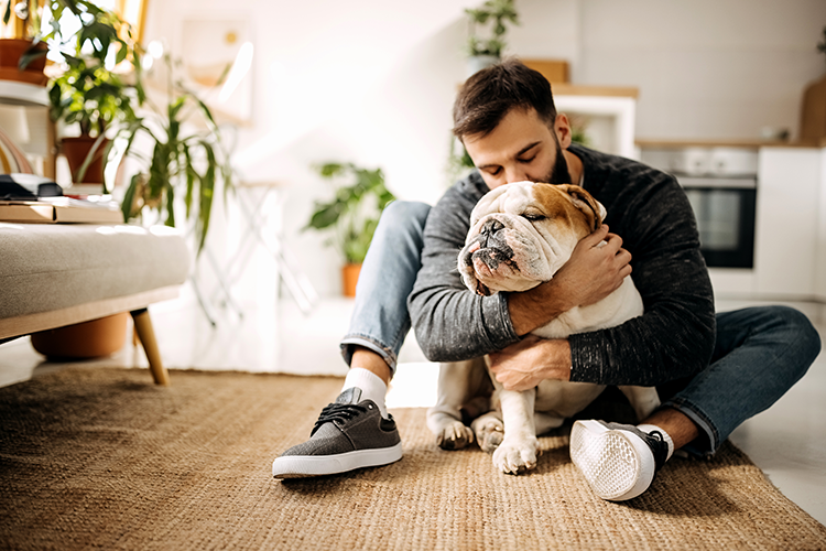 A dog and its owner sitting on the floor together.